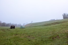 Our small tent in a large misty field with a tractor