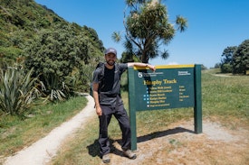 Me standing next to a Heaphy Track sign, having finished the walk
