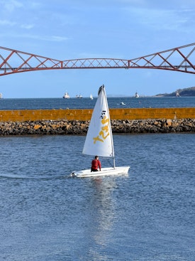 A boat in front of the rail bridge